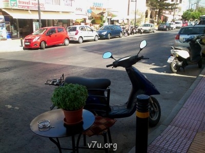 Ну, вот такая провинциальная улочка в Херсониссосе, припаркованы: мотороллер, кофейный столик с цветочком и стульчик...
