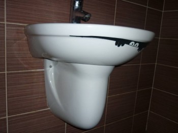 Наклеили под раковиной. Она заметна только если сесть.