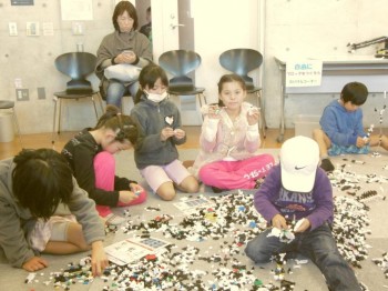 собирают  пазлы... меня  эта  девочка  филиппинка  ваще достала   все  фотки портит  своей  маской...  ну ладно бы  болела  а  она  ваще  ее никогда не снимает. Нормальное  дите  без дефектов  кроме  одного